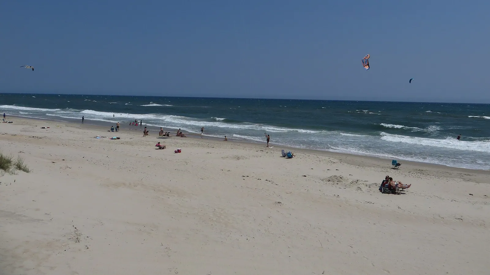 Kitesurfing kites flying over the windy surf at a sandy beach