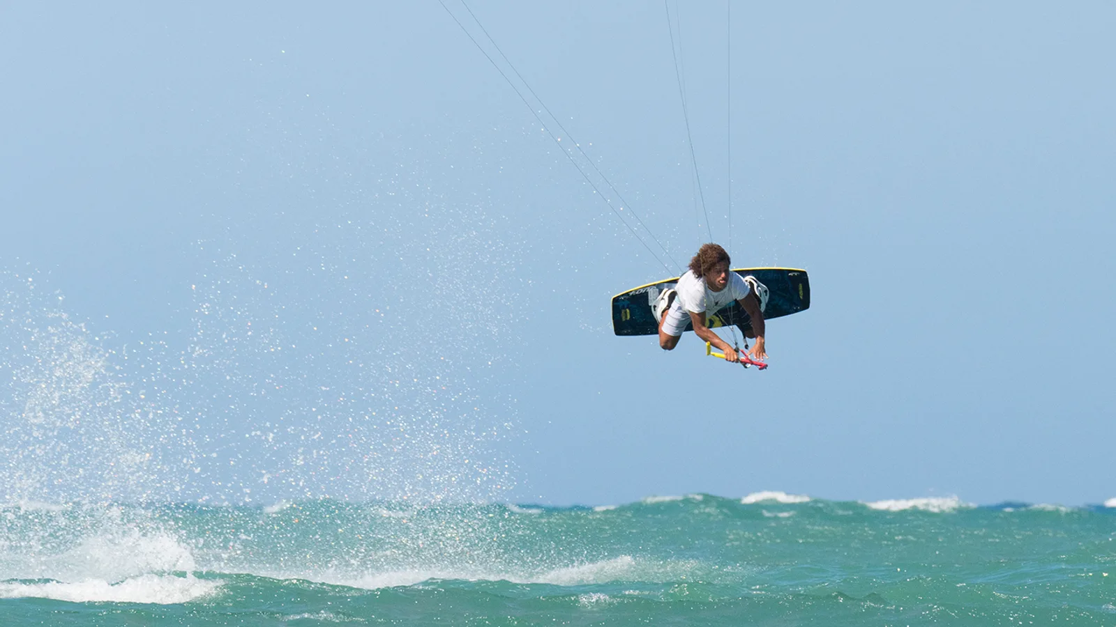 Kites lining Cabarete Bay in the afternoon trade wind, palm trees along the beach