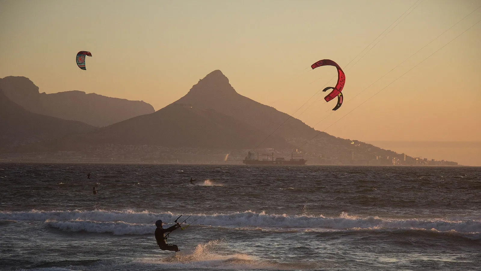 A kitesurfer boosting in front of Table Mountain at Bloubergstrand, Cape Town