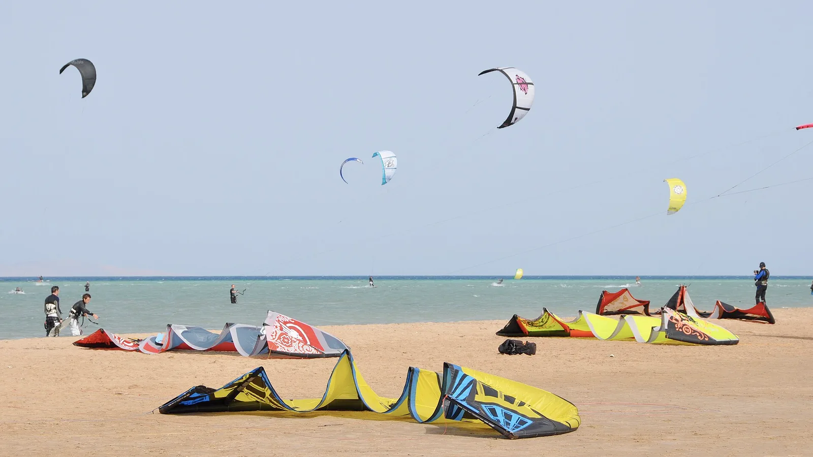 Kitesurfers on the turquoise, waist-deep lagoon at El Gouna with kites stacked downwind