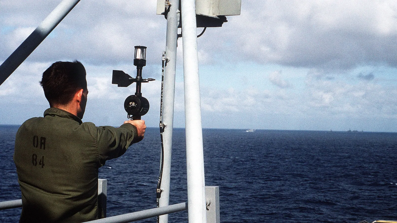 A cup anemometer spinning against a bright sky, measuring wind speed