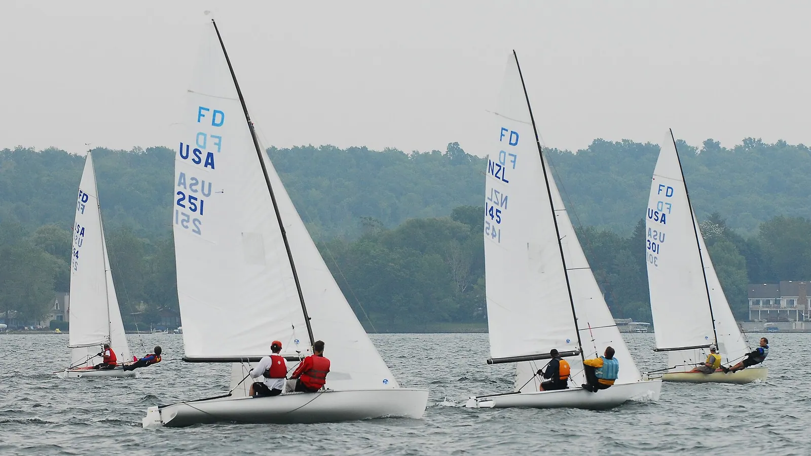 A fleet of Flying Dutchman sailing dinghies racing in a fresh breeze