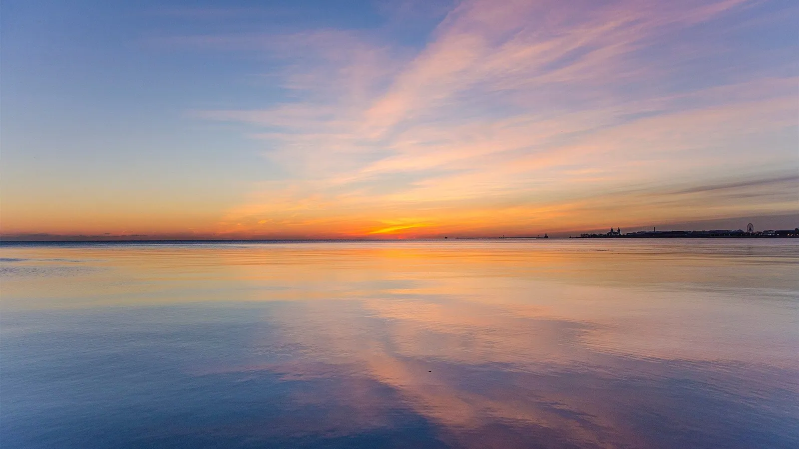 A calm sea under a colourful sunset sky